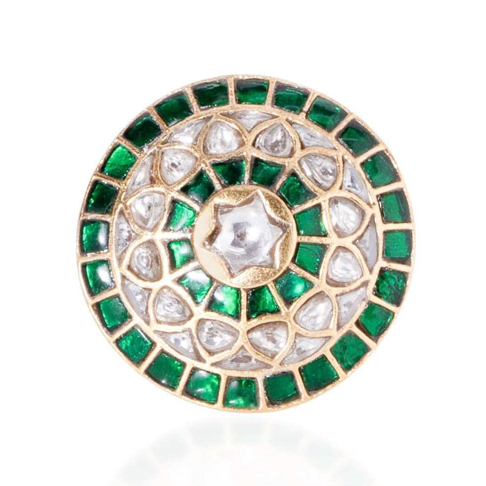 Decorative brooch with green and gold details on a white background