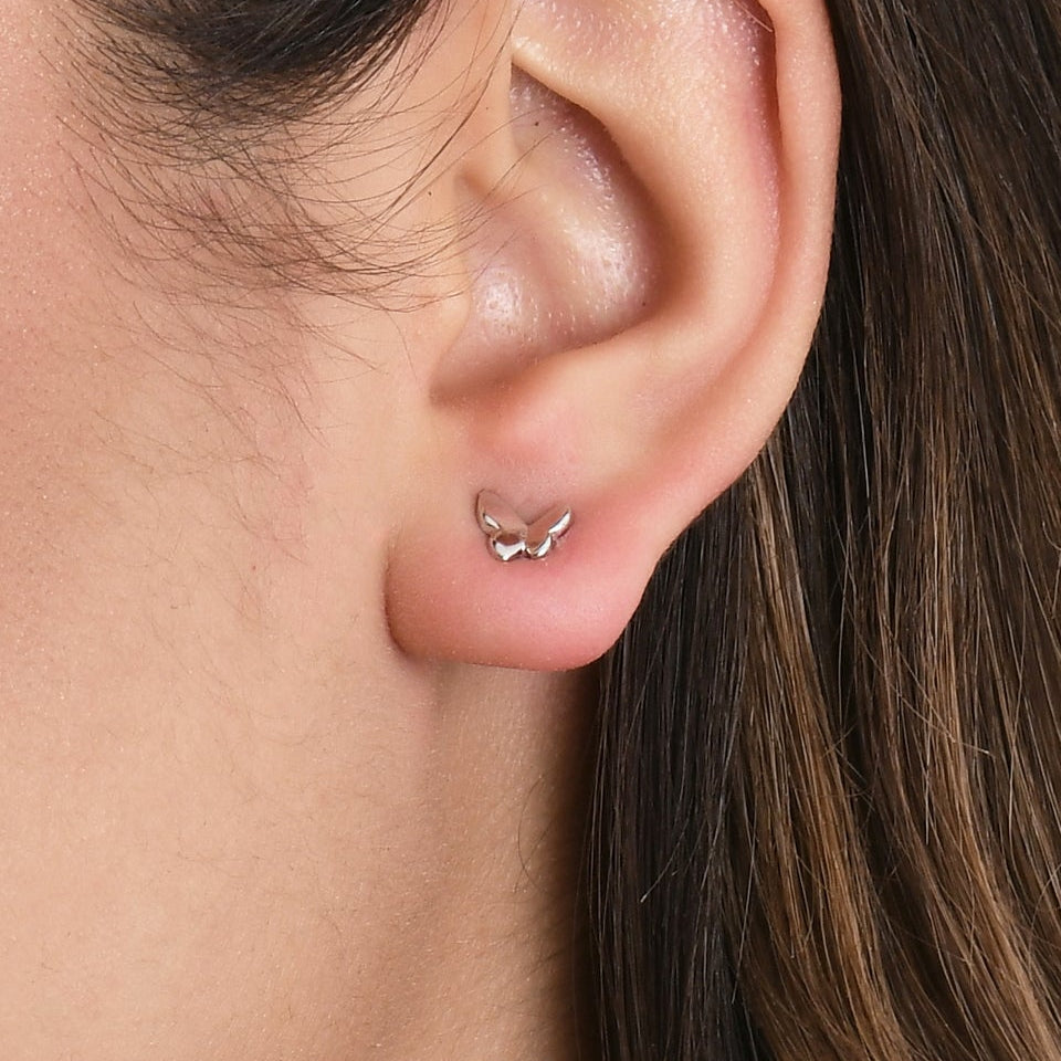 Close-up of a woman wearing a small earring on a white background