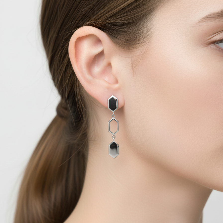 Woman wearing a pair of geometric earrings with a plain background