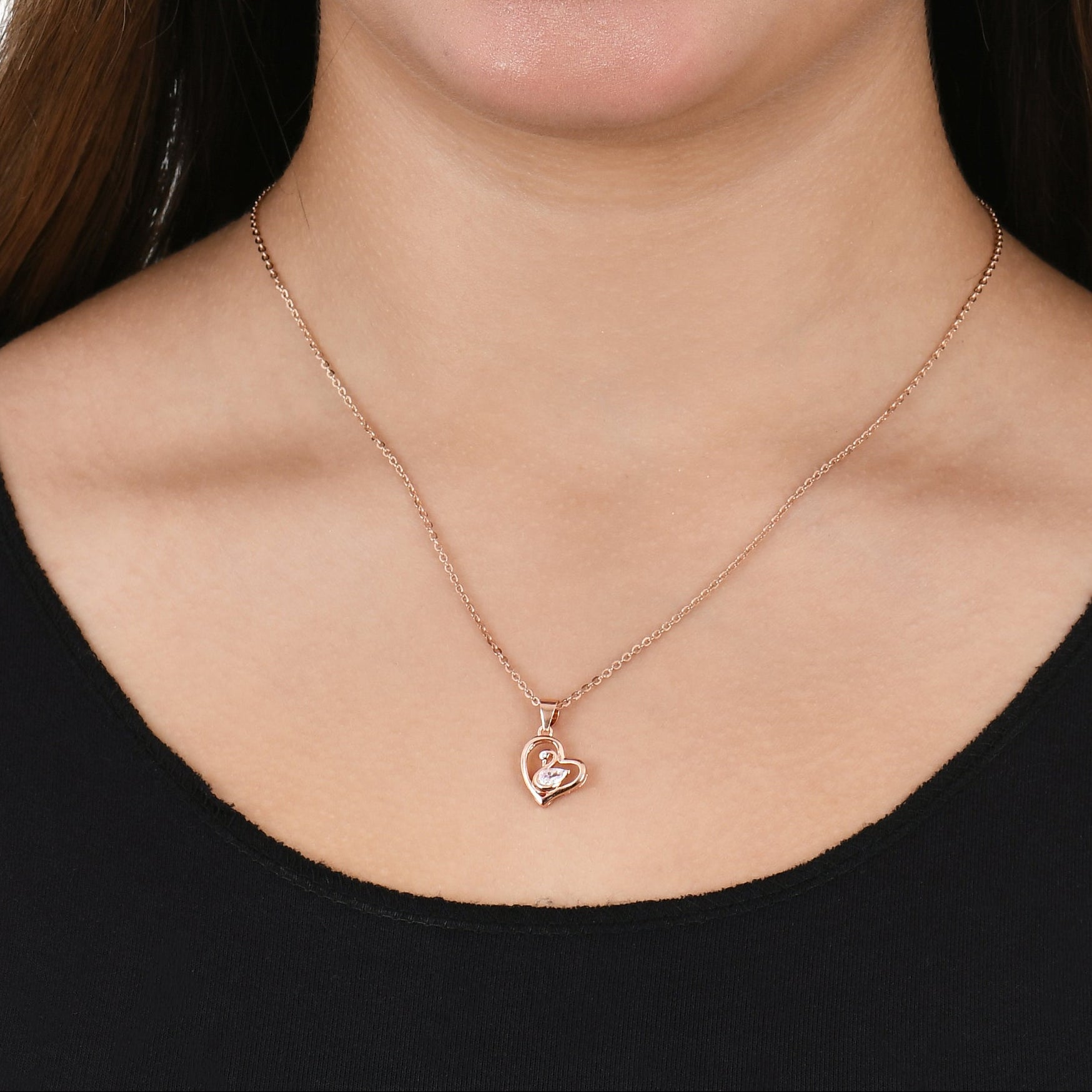 Woman wearing a black top and necklace on a white background