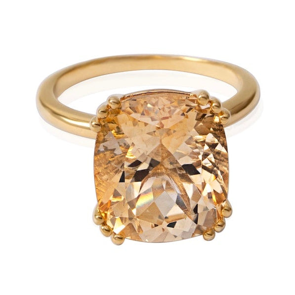 Gold ring with a large beige gemstone on a white background