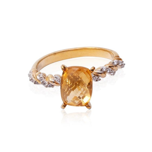 Gold ring with a yellow gemstone on a white background