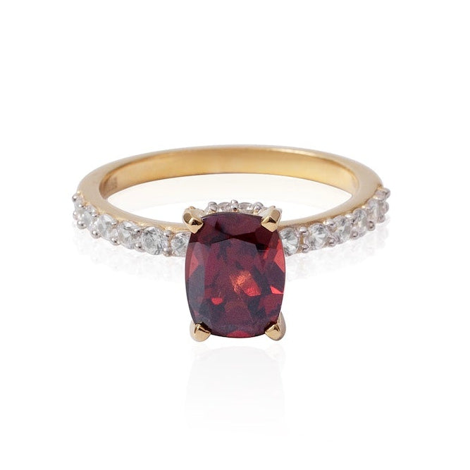 Gold ring with a red gemstone on a white background