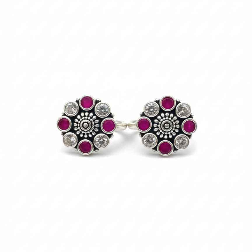 Pair of earrings with floral design and pink gemstones on a white background