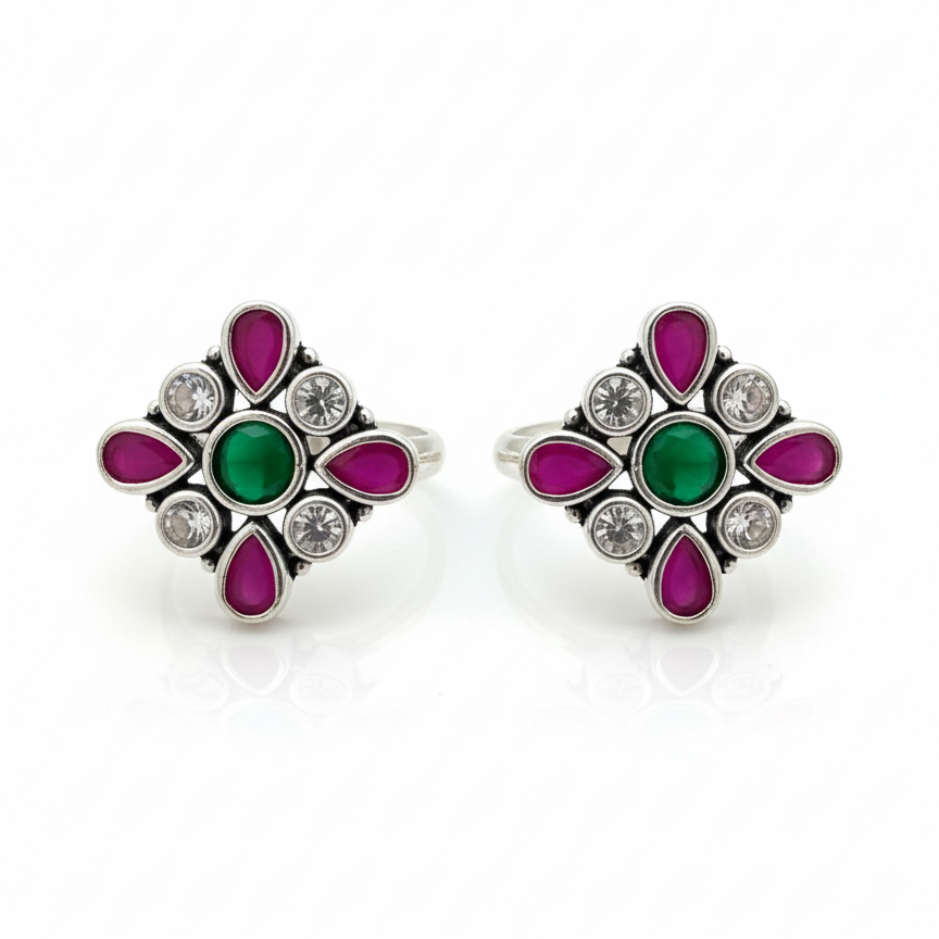 Pair of earrings with green and pink gemstones on a white background