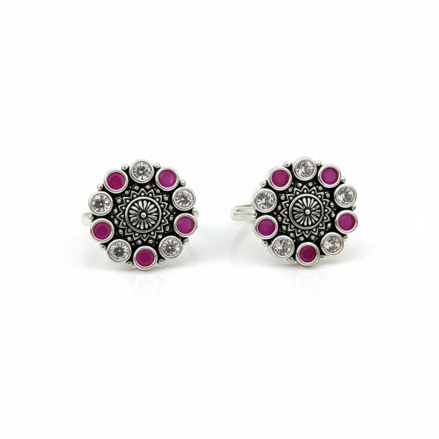Pair of round silver earrings with pink gemstones on a white background