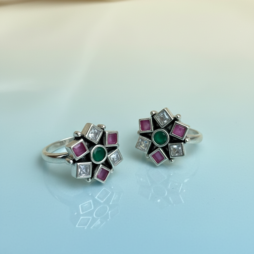 Pair of silver rings with gemstones on a light blue background
