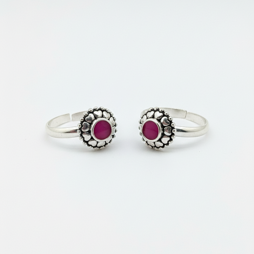 Pair of silver rings with red gemstones on a white background