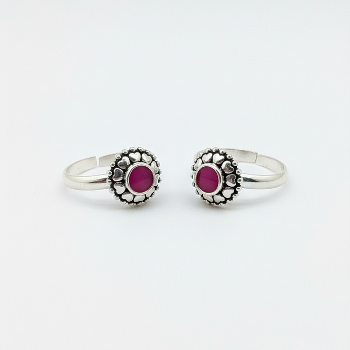 Pair of silver rings with red gemstones on a white background