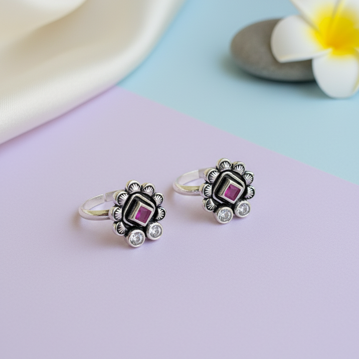 Silver earrings with gemstones on a pastel background