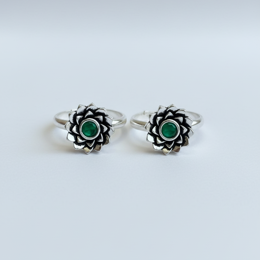 Pair of silver rings with green gemstones on a white background