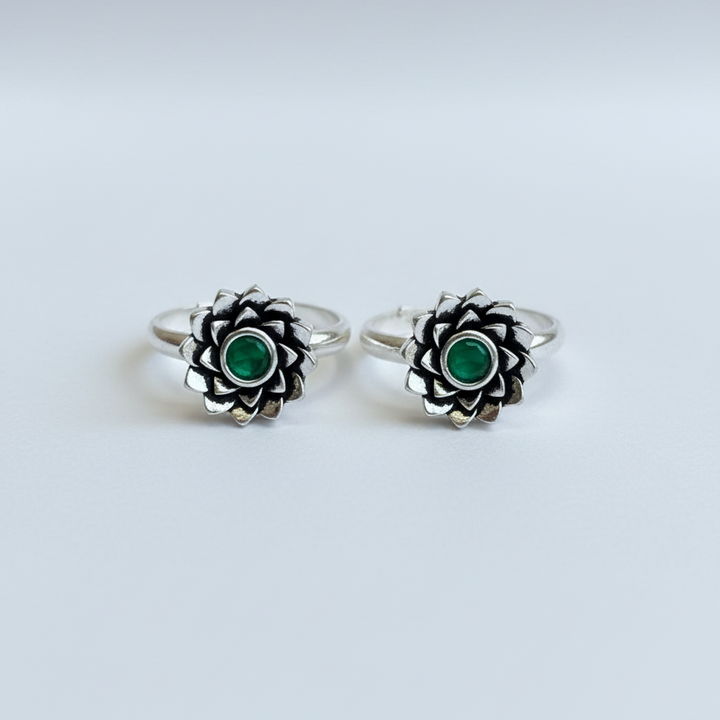 Pair of silver rings with green gemstones on a white background
