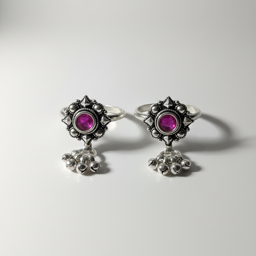 Pair of earrings with pink gemstones and silver designs on a white background