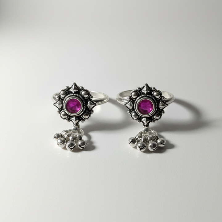 Pair of earrings with pink gemstones and silver designs on a white background