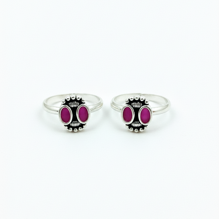 Two silver rings with pink gemstones on a white background