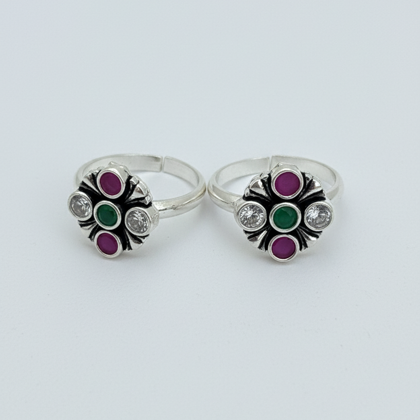 Pair of silver rings with colorful gemstones on a white background