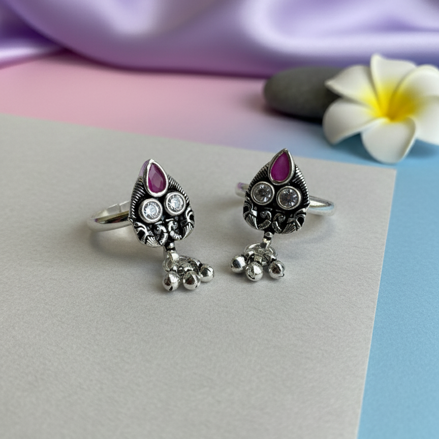 Silver rings with pink gemstones on a pastel background