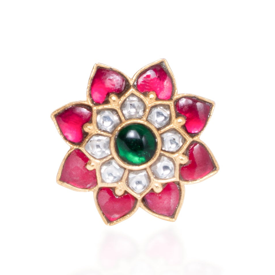 Jewelry item with pink floral design and green gemstone on a white background