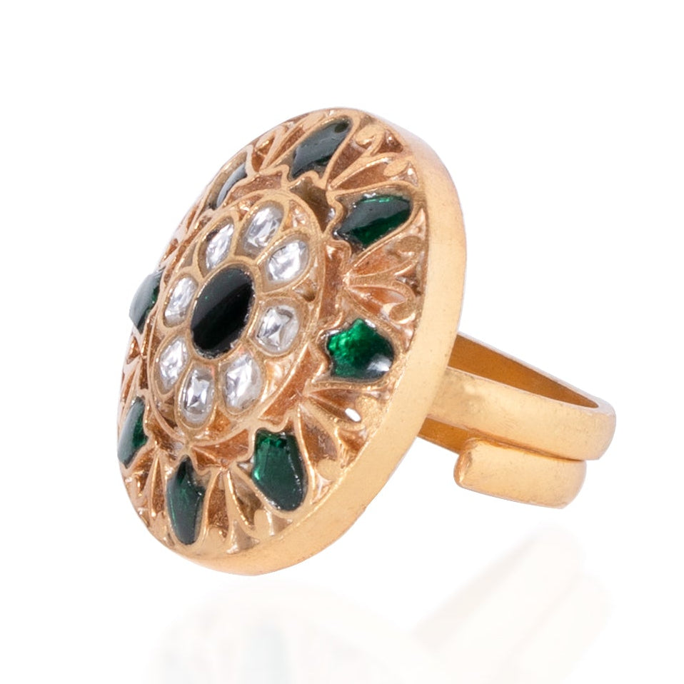 Gold ring with green gemstones on a white background