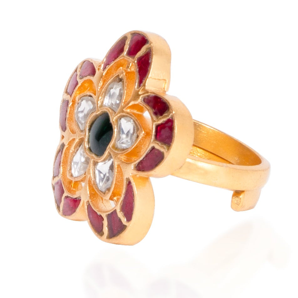 Gold ring with a floral design and gemstones on a white background